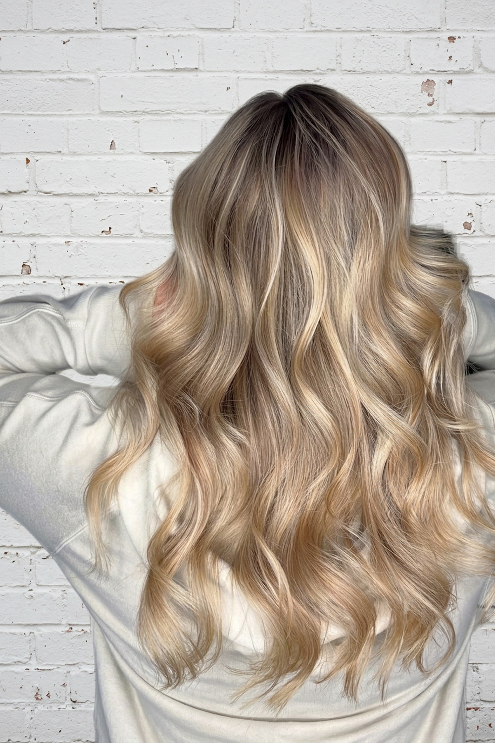 Soft beige blonde balayage with lived-in roots, styled in loose waves at Wicked Hair Draper.
